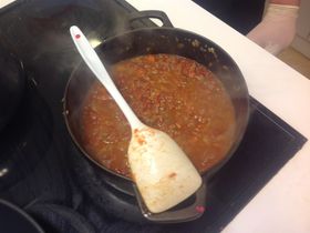 Tilsett kjøttdeig, tomater og krydder, og så la det koke noen timer til ferdig ragù